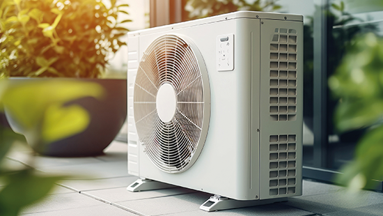 Kleine Klimaanlage auf einer Terrasse zwischen Pflanzen, symbolisiert den SWBB Stromtarif für Wärmepumpen, speziell für effiziente und nachhaltige Heizlösungen.