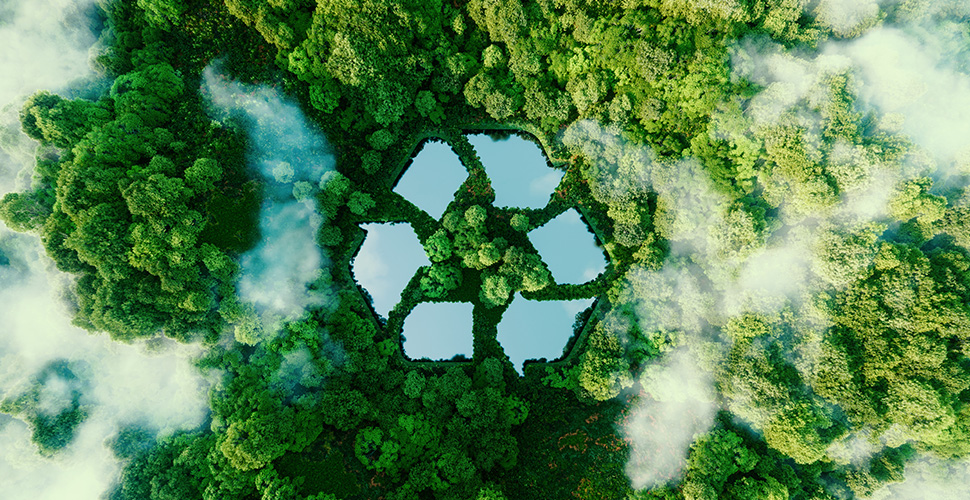 Luftaufnahme von Wald mit Wasserflächen in Form von Pfeilen, bilden einen Recyclingpfeil