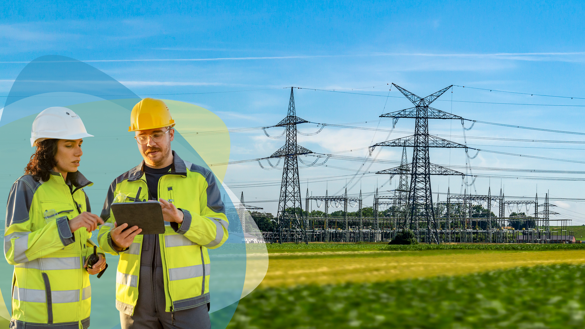 Zwei Mitarbeiter:innen der SWBB betrachten ein Tablet, im Hintergrund Freileitungsmasten in grüner Landschaft unter blauem Himmel